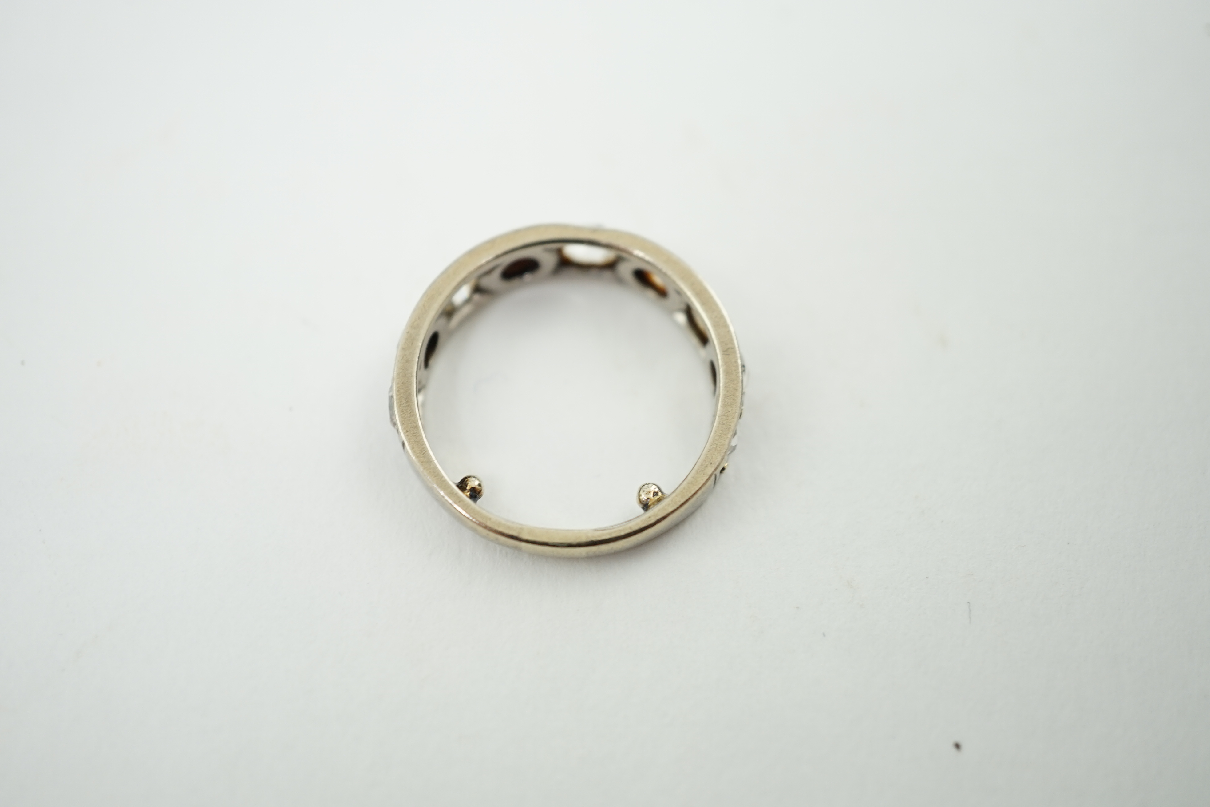 A white gold and nine stone graduated rose cut diamond set half hoop ring